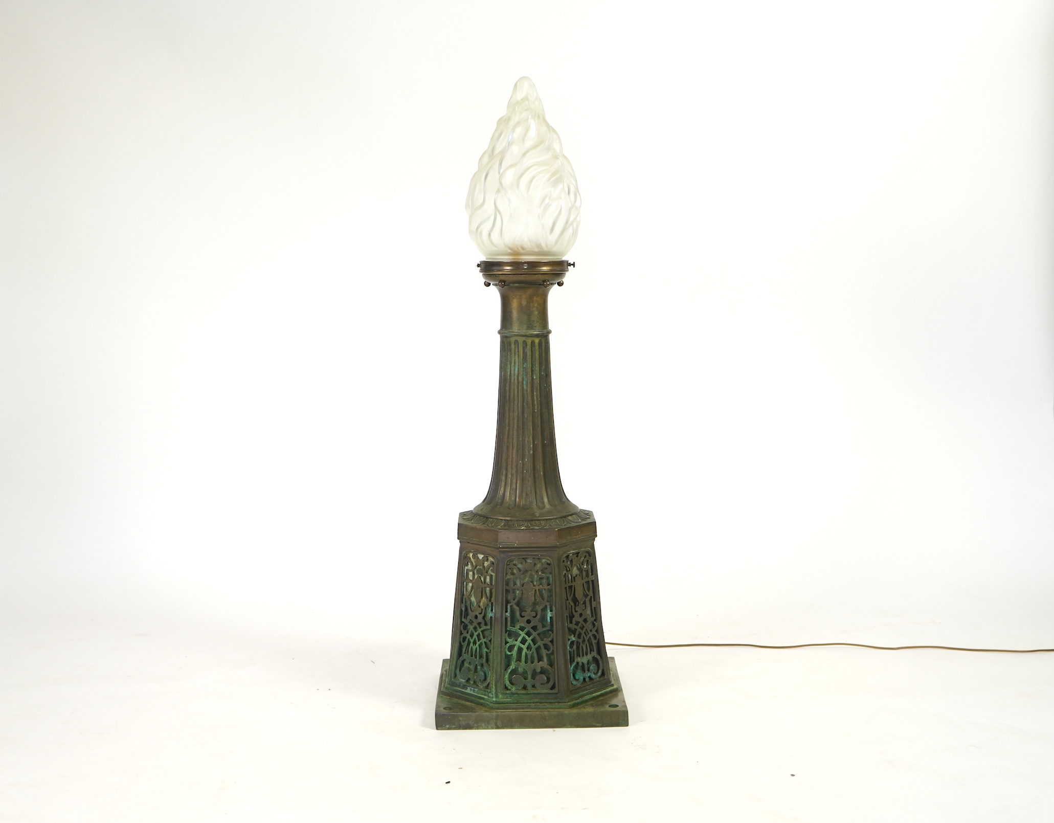 A late 19th century bronze post lamp, the fluted column above a strapwork pierced base, with modern frosted glass flame shade, 137cm high